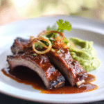 Schweinerippchen mit Chipotle-Butter und knusprigem Schalotten-Avocado-Stampf